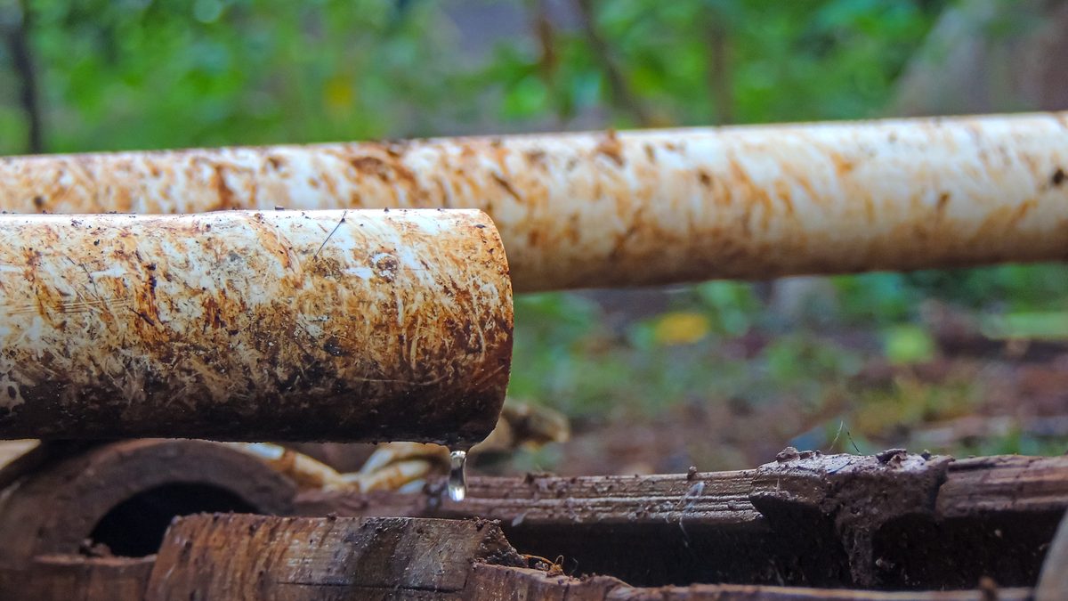 Heavily corroded pipe with a drop forming at its cut end